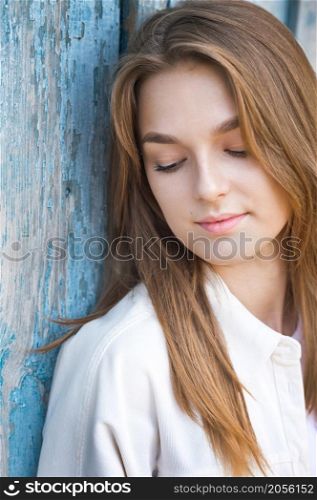 A beautiful portrait of a young girl in the sunlight.. A beautiful young girl is leaning against the wall in the sunlight 3686.