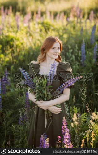 A beautiful red-haired girl in a thicket of lupine.. Portrait of a red-haired girl in a thicket of lupin 3271.