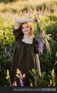 A beautiful red-haired girl in a thicket of lupine.. Portrait of a red-haired girl in a thicket of lupin 3276.