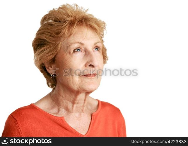 A beautiful red haired senior lady daydreaming with a hopeful expression. Isolated on white.