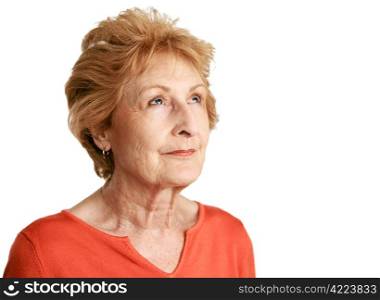 A beautiful red haired senior lady daydreaming with a hopeful expression. Isolated on white.