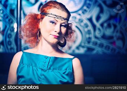 A beautiful redhaired woman smiling . Disco club scene.