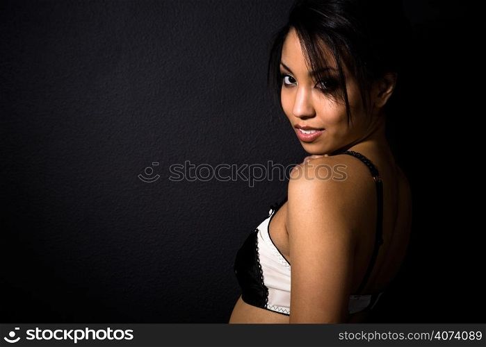 A beautiful sexy african american woman wearing lingerie shot in black background