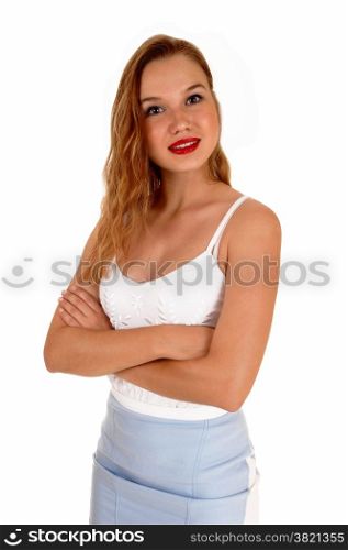 A beautiful slim blond woman standing isolated for white backgroundlooking into the camera with her arms crossed.