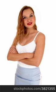 A beautiful slim blond woman standing isolated for white backgroundlooking into the camera with her arms crossed.