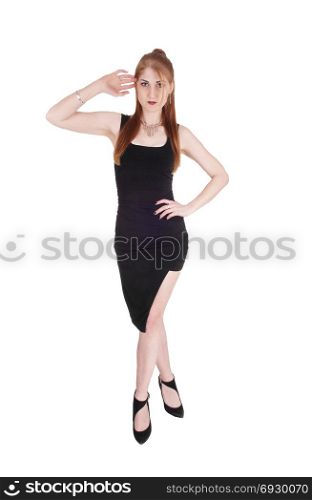 A beautiful slim woman in a black dress and long brunette hair standingfrom the front, isolated for white background