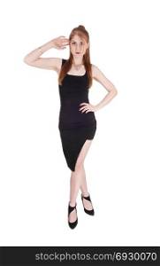 A beautiful slim woman in a black dress and long brunette hair standingfrom the front, isolated for white background