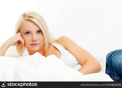 A beautiful smiling young woman lying in bed