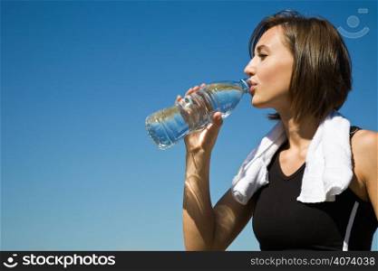 A beautiful sporty caucasian girl drinking water after exercise