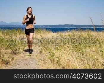 A beautiful sporty caucasian girl running on the beach