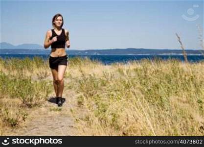 A beautiful sporty caucasian girl running on the beach