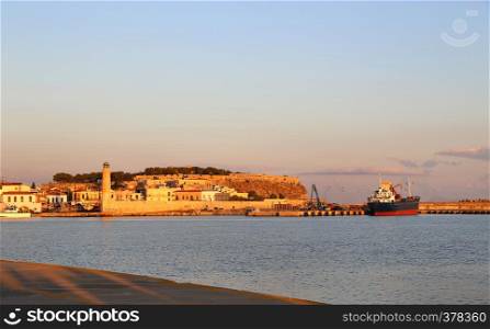 A beautiful view of harbour in Rethymno with lighthouse and fortress Fortezza at sunrise, Crete island, Greece