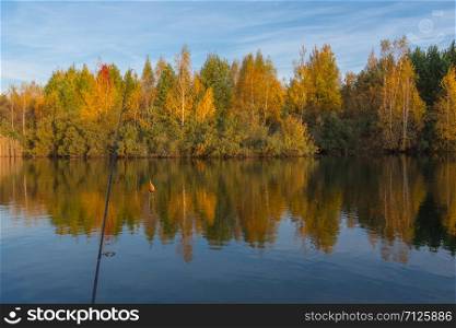a beautiful view of the nameless lake in the Moscow region, the photo was taken in September 2019 in the early morning, fishing rods are also visible in the photo. lake in autumn