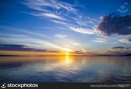 A beautiful view of the sea with the sun shining in a blue sky in the background. Beautiful view of the sea with the sun shining in a blue sky in the background