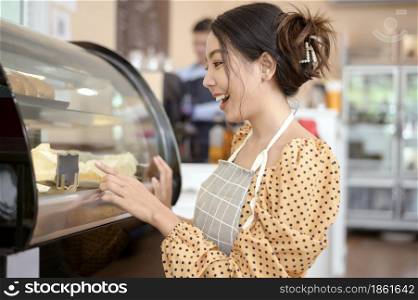 A beautiful woman bakery or coffee shop owner is smiling in her shop