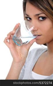 A beautiful woman drinking a glass of water.