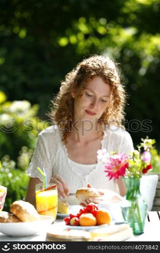 A beautiful woman eating a meal in her garden