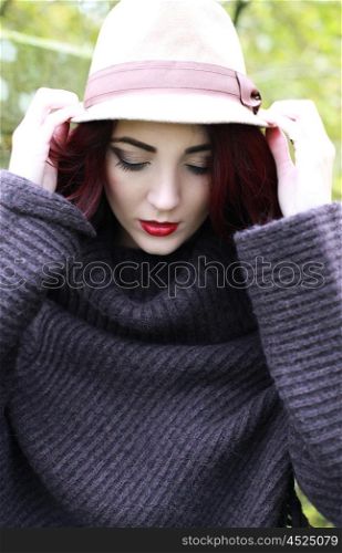 A beautiful woman holding on to her hat