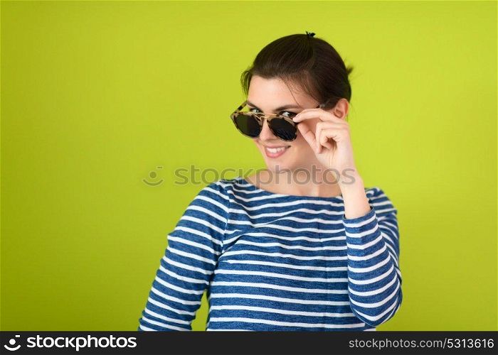 a beautiful woman  in sunglasses posing in front of a green background

