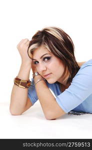 A beautiful woman lying on the floor in a studio, in closeup, only her headand upper body, looking into the camera, on white background.