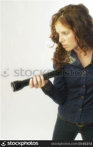 A beautiful woman poses with a torch searching for something.