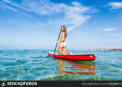 A beautiful woman practicing paddle on a beautiful sunny day