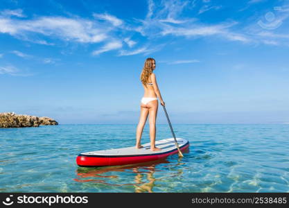 A beautiful woman practicing paddle on a beautiful sunny day