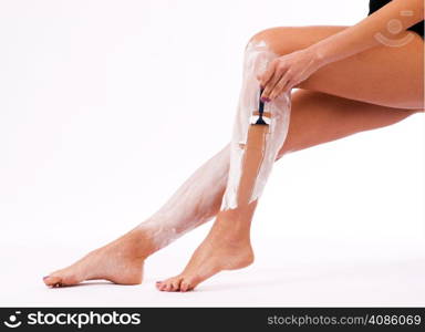 A beautiful woman shaves her legs