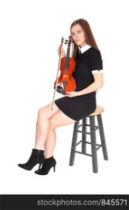 A beautiful woman sitting in a black dress holding her violin resting looking into the camera, isolated for white background