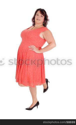 A beautiful woman standing on one leg, in a red dress in profile in her forties, isolated for white background