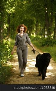 A beautiful woman walking her dog