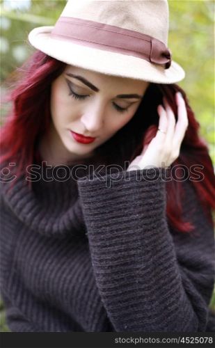 A beautiful woman wearing a hat with eyes cast down