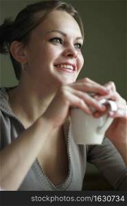 A beautiful woman with a cup of coffee or tea. Shallow depth of field.