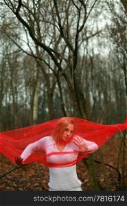 A beautiful woman with a red shawl on forest