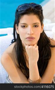 A beautiful yong Hispanic woman next to a swimming pool