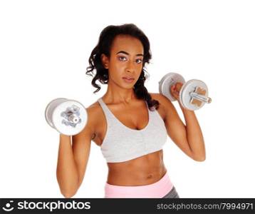 A beautiful young African American woman in a gray sports bra exercising with dumbbell&rsquo;s, isolated for white background.