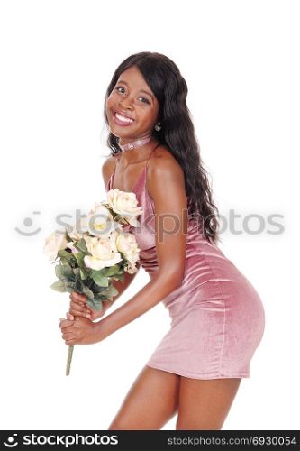 A beautiful young African woman standing in a short pink dress holding a bunch of yellow roses, isolated for white background