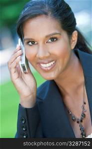 A beautiful young Asian businesswoman with a wonderful smile chatting on her cell phone.