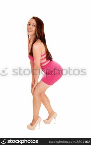 A beautiful young Asian woman in a pink dress standing in profile, isolated for white background.