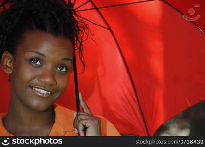 A beautiful young black woman holding an umbrella