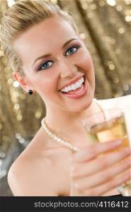 A beautiful young blond haired, blue eyed woman enjoying a glass of champagne