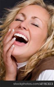 A beautiful young blond woman laughing spontaneously