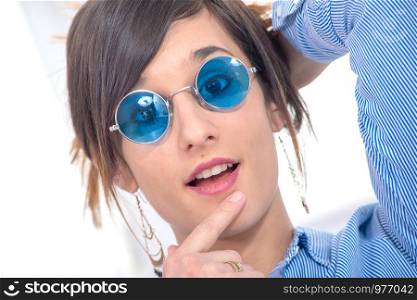 a beautiful young brunette woman with blue glasses