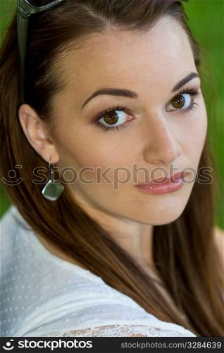 A beautiful young brunette woman with striking brown eyes shot outside in natural light