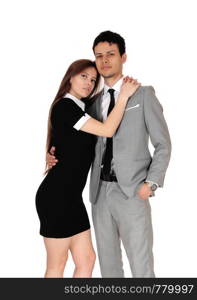 A beautiful young couple standing in a gray suit and black dress in a loving pose, isolated for white background
