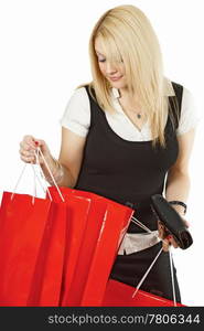 A beautiful young female looking in her shopping bags with a satisfied smile on her face.