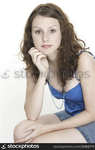 A beautiful young female model rests her head on her hand