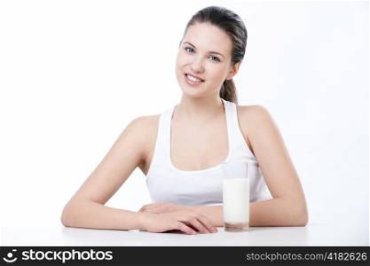 A beautiful young girl with a glass of milk on a white background