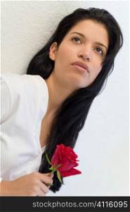 A beautiful young Hispanic woman holding a rose