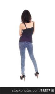A beautiful young Hispanic woman in a black t-shirt and blue tights standing from the back, isolated for white background.